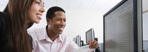 An instructor and a student looking at a computer screen